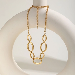 Détail d'un bracelet gourmette doré avec chaîne réglable sur un support géométrique épuré