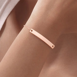 Close-up of polished rose gold curved bar bracelet on a female wrist for a stylish look