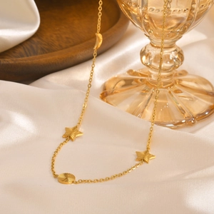 Details der goldenen Himmelsanhänger mit Mond und Sternen an einer Edelstahl-Halskette