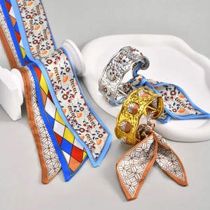 Detail of vintage gold and silver hammered cuffs with colorful printed silk scarves