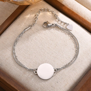 Macro shot of silver stainless steel double chain bracelet with engravable round tag detail