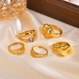 5-teiliges goldenes Herz-Ring-Set mit blauen Zirkonia auf weißem Seidenhintergrund