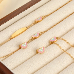 Detail eines goldenen Schmetterlings-Schmucksets mit Emaille und gravierbarer Platte
