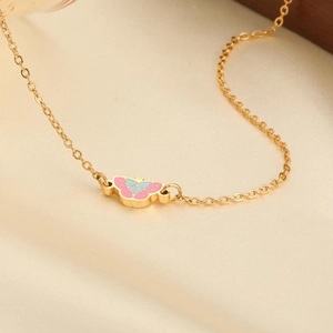 Nahaufnahme des goldenen Schmetterlingsanhängers mit rosa und blauem Emaille-Finish
