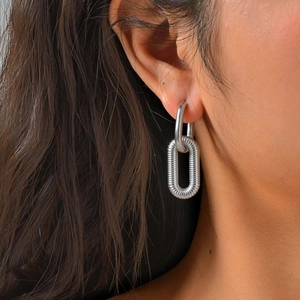Close-up of textured silver U-shaped double hoop earrings on model for a modern look