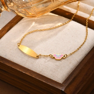 Detailansicht goldener Schmetterlingsanhänger und gravierbare Platte an feiner Kette