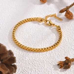 Golden stainless steel wheat chain bracelet for women with lobster clasp on white background