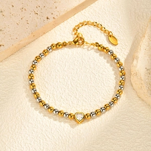 Detail van de hartvormige zirkoon hanger aan een tweekleurige kralenarmband