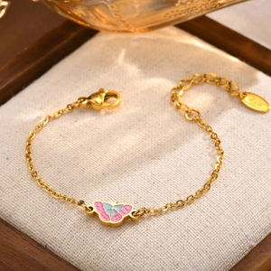 Detailaufnahme des goldenen Schmetterlingsarmbands mit rosa Emaille und K18 Anhänger