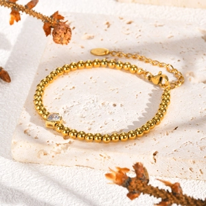 Detail van de gouden kralenarmband met hartvormige zirkoon en handige karabijnsluiting