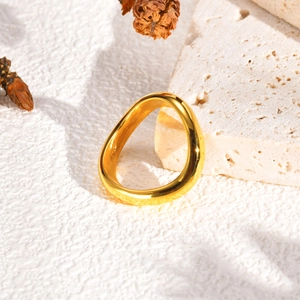 Vue détaillée d'une bague dorée ondulée à trois couches sur pierre travertin