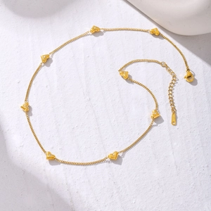 Collier minimaliste en acier doré avec sept breloques cœur en zircon sur fond de pierre