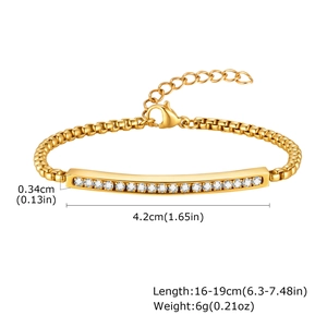 Gros plan d'un bracelet en acier doré avec barre de zircons et chaîne à mailles carrées
