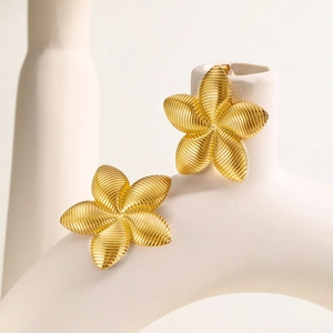Boucles d'oreilles fleur dorées minimalistes avec texture filetée sur support en céramique