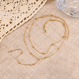 Detailed view of golden beaded double layer Y-necklace with adjustable lobster clasp closure