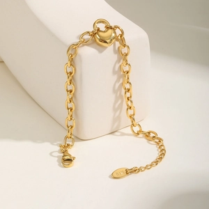 Dettaglio macro del bracciale a catena dorato con lucchetto a cuore e marchio K18