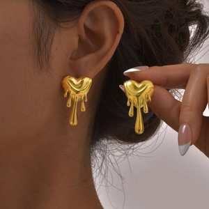 Boucles d'oreilles cœur irrégulier style lave dorées portées par un mannequin