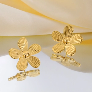 Elegante goldene Blumenohrstecker aus Edelstahl mit strukturierten Blüten auf Satin-Stoff