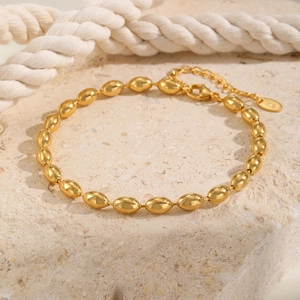 Detail einer 18 Karat vergoldeten Ovalperlen-Fußkette mit Karabinerverschluss und K18-Tag