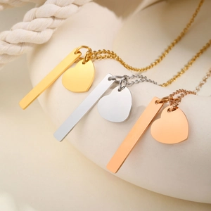 Three minimalist stainless steel necklaces with vertical bars and heart charms in gold and silver