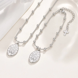 Detail van roestvrijstalen ketting en armband set met Maagd Maria religieuze hanger