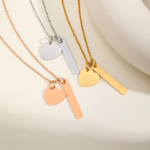 Detailed view of polished heart and vertical bar pendants in rose gold, silver, and gold