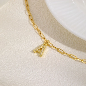 Macro-opname van gouden letter A hanger met zirkonia micro-inleg op een paperclip ketting
