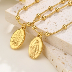 Detailopname van gouden roestvrijstalen Maria-hangers en de kralenkettingstructuur