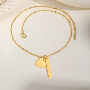 Detailed shot of a gold-plated stainless steel bar necklace with a heart-shaped pendant