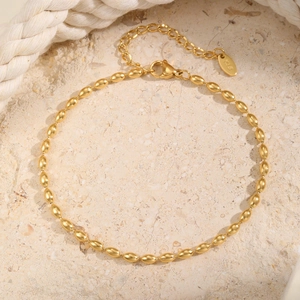 Makroaufnahme der goldenen Kugel-Fußkette mit Karabinerverschluss und K18 Gravur-Anhänger