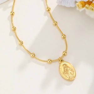 Detail van de gouden slangenketting met Maria-medaillon en decoratieve kralen