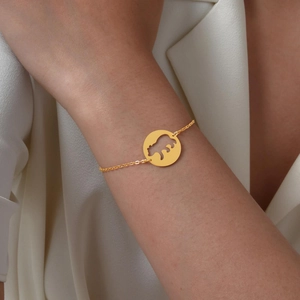 Bracelet doré pour femme avec pendentif ours évidé sur fond de soie blanche