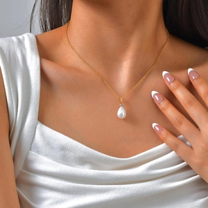 Elegante vergoldete Edelstahlkette mit Tropfenperle und Zirkon am Modell getragen