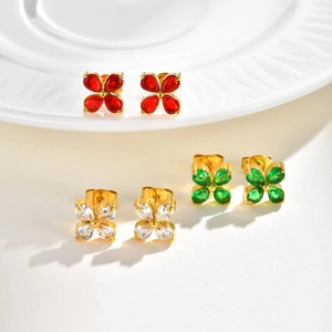 Detailed macro of gold flower earrings with green, red, and clear zircon petals