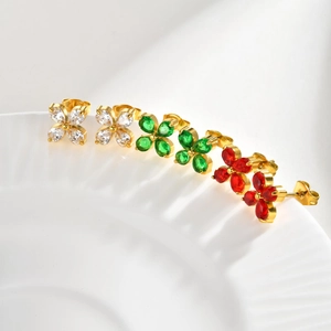 Detail of flower stud earrings featuring emerald green and white zircon petals in gold plating