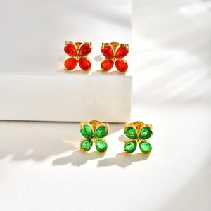 Detail of emerald and red clover stud earrings with gold plating and faceted stones