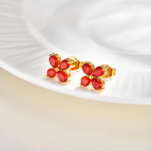 Detailed side view of four-petal flower stud earrings with red zircons and gold plating