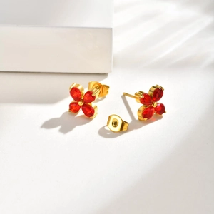 Detail of four-petal flower earrings with red zircon crystals and golden studs