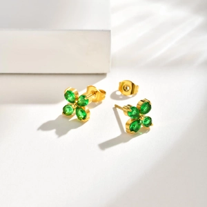 Close-up of gold clover stud earrings featuring four emerald green drop-shaped zircons