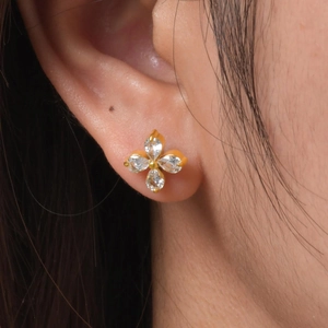 Women's gold flower stud earrings with white marquise crystals in a four-petal design
