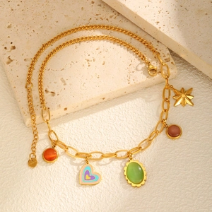 Gold stainless steel necklace with opal charms and colorful heart pendant on stone surface