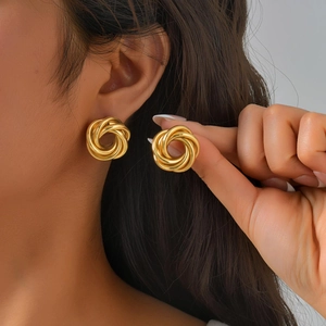 Detailansicht stilvoller vergoldeter Knoten-Ohrstecker getragen von einem Model