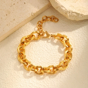 Detail of gold chunky link bracelet with textured surface and lobster clasp closure
