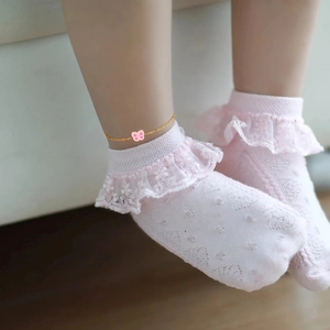 Dettaglio del ciondolo a farfalla in smalto rosa su catena dorata per bambini e neonati