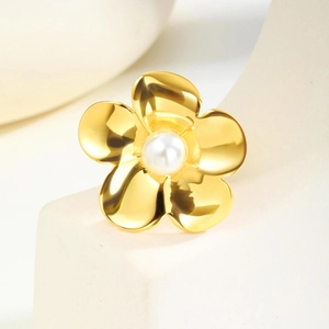Elegante anello a fiore dorato con perla su espositore in ceramica bianca
