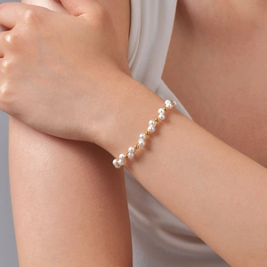 Bracelet élégant en acier inoxydable doré 18 carats avec perles blanches sur poignet