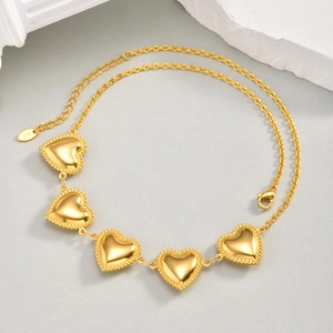 Detail van de 18K goudkleurige hartjesketting met milgrain randen en karabijnsluiting