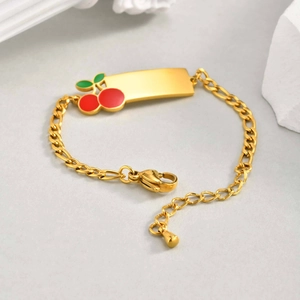 Détail du bracelet Figaro doré en acier inoxydable avec breloque cerise et plaque vierge