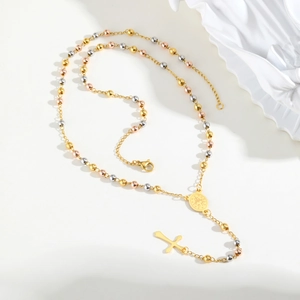 Macro view of tricolor metal beads, crucifix pendant and holy medal on rosary necklace