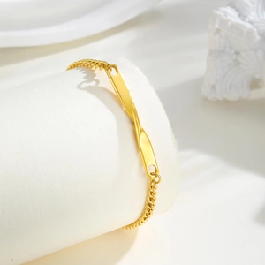 Détail de la barre torsadée Mobius dorée sur un bracelet gourmette poli